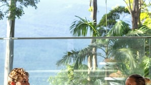 Una habitación con un gran ventanal que ofrece vistas de la vegetación tropical y un cuerpo de agua.