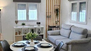 A modern living room with a dining area. - Minichalet Jacaranda with swimming pool, garden and barbecue. (Chiclana)