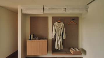 Um closet amplo com um armário de madeira, roupão pendurado e um cesto de vime.