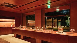 A bar area with a long counter, various glassware, and a large window. - IJE Gyeongju (Gyeongju)