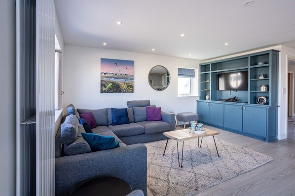 Spacious living room with corner sofa and full-length sea view windows, accessible single-storey holiday bungalow in Rhosneigr, Anglesey - Morawelon: 100m from the beach in Rhosneigr (Rhosneigr)