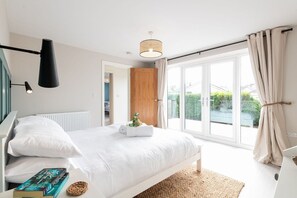 Master bedroom with patio doors opening to the rear decked terrace, pet-friendly holiday bungalow in Rhosneigr, Anglesey - Morawelon: 100m from the beach in Rhosneigr (Rhosneigr)