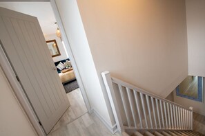 A staircase with white railings leading to a landing.