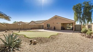 A single-story building with a flat roof, a patio area with outdoor furniture, and a small lawn. - Pet-Friendly and Family-Friendly (Casa Grande)