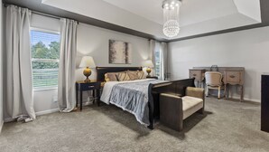 A modern bedroom with a large bed, bedside tables, a desk, and a chair. - Peaceful Midland Cottage- Family & Pet Friendly, Near Golf, Parks, Nature Trail & Shopping! +15% Off (Midland)