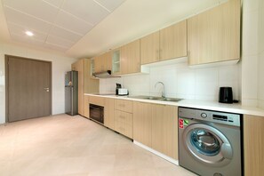 Une cuisine moderne avec des meubles en bois, un lave-vaisselle encastré et un lave-linge à chargement frontal.
