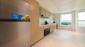 Eine moderne Küche mit Holzschränken, einem Edelstahlkühlschrank und einem Fenster mit Blick auf die Stadt.