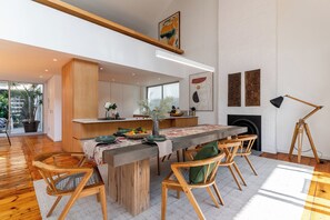 A modern dining area with a wooden table, chairs, and a fireplace.