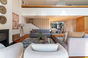 A modern living room with a grey sofa set, a coffee table with decorative items, and a fireplace.