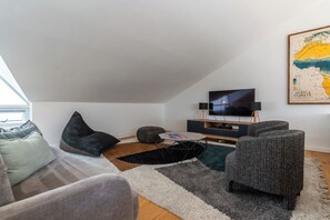 A modern living room with a flat-screen TV, comfortable seating, and a large map on the wall. - Savanna House - Location, Luxury and Lifestyle (Cape Town)