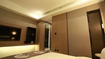 A hotel room with a bed, a large mirror, and a wardrobe.