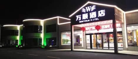 A hotel entrance with illuminated signage and a modern design.
