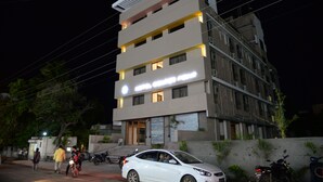 Un edificio de varios pisos con diseño moderno, que destaca por una entrada con escalones y un cartel sobre la puerta.