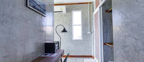 Ein modernes Zimmer mit einem Holztisch, einer schwarzen Lampe und einem Fenster.