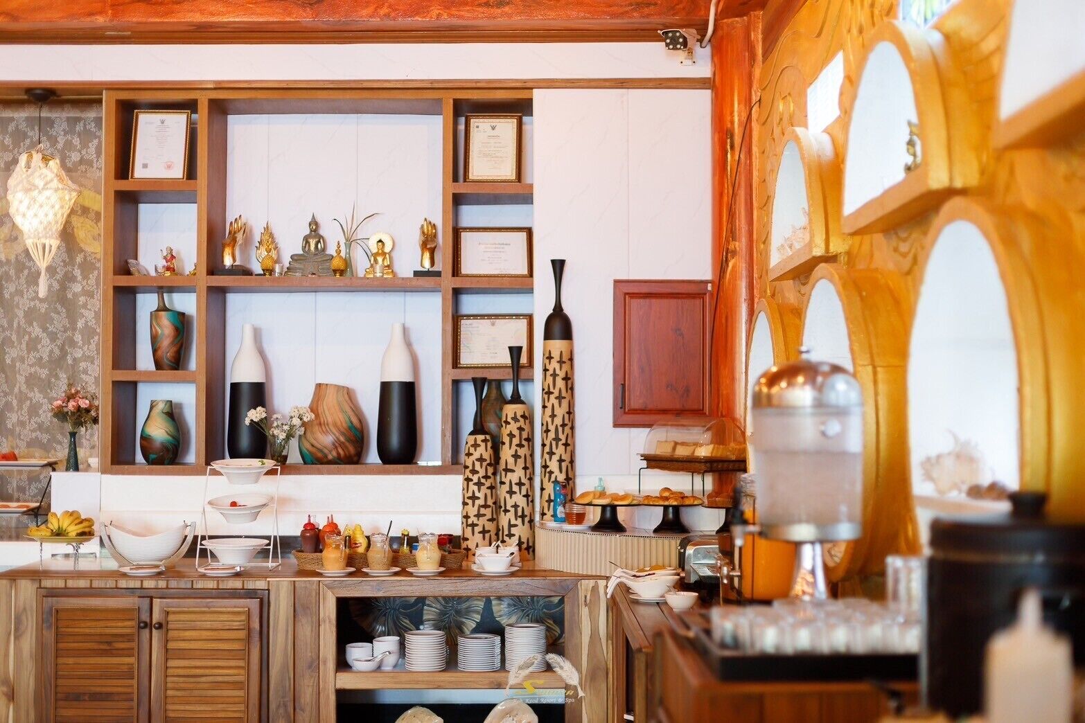 Una cocina bien organizada con armarios de madera, estantes con adornos y una variedad de utensilios de cocina.