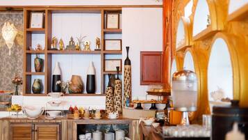 Una cocina bien organizada con armarios de madera, estantes con adornos y una variedad de utensilios de cocina.