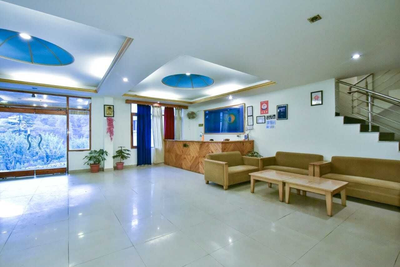 A spacious lobby with a reception desk, seating area, and a staircase.
