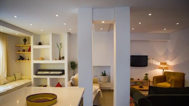 A modern living room with a sofa, a yellow armchair, a TV, and a bookshelf. - Peaceful corner in the center of La Marsa (Tunis)