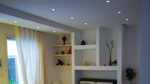 A modern living room with a built-in sofa, white shelves, and a piano. - Peaceful corner in the center of La Marsa (Tunis)
