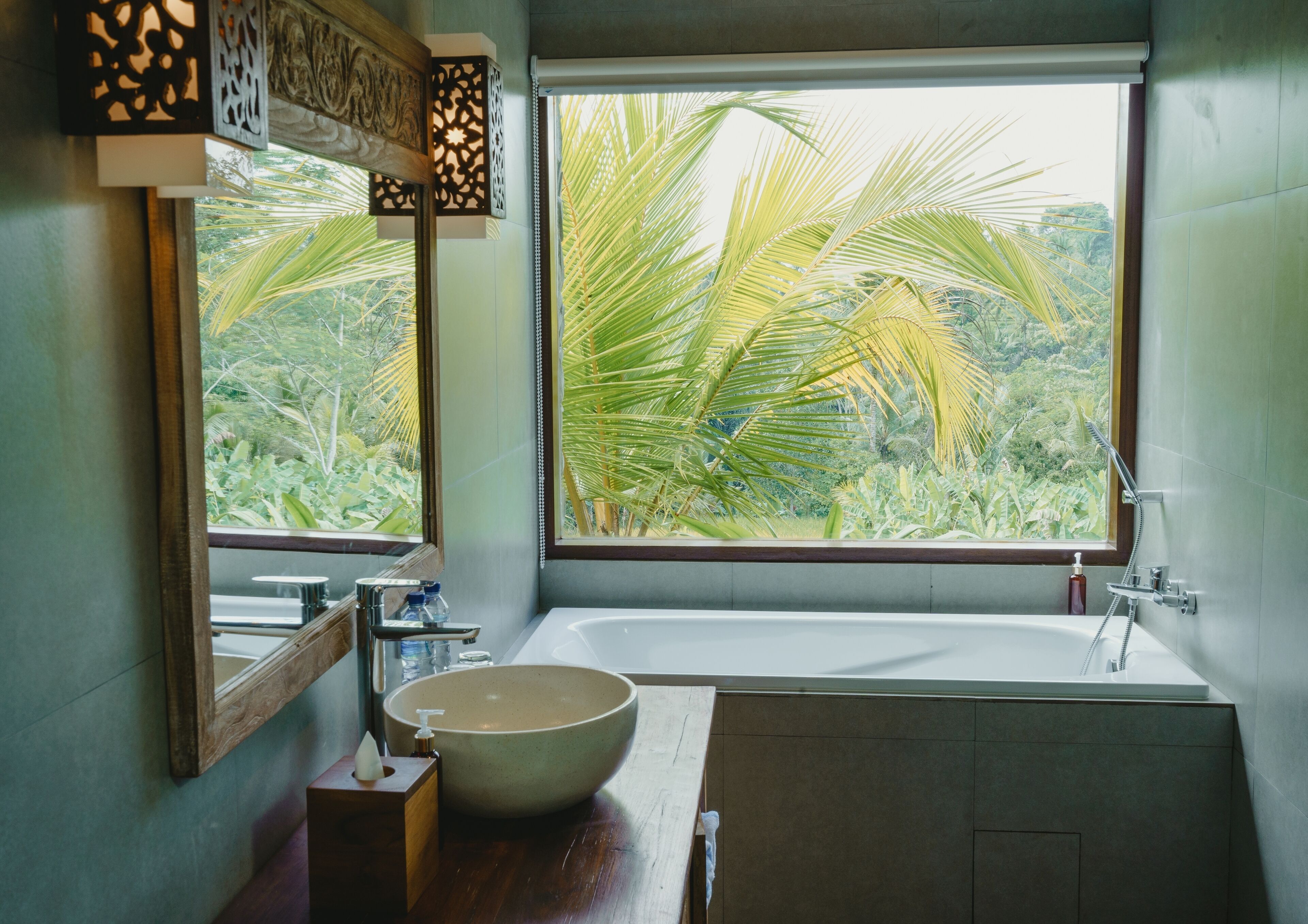 Un baño con una ventana grande, un lavabo, un espejo y una ducha.