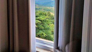Una habitación con ventana que da a un paisaje boscoso.