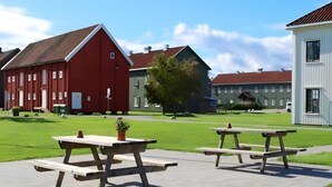 Un parc avec des tables de pique-nique et une grange rouge.