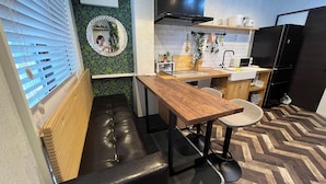 A modern kitchen with a wooden bench, a round mirror, and a herringbone floor pattern. - Ikebukuro, cafe style, 2LDK, detached house, 2 shower rooms, 2 toilets (豊島区)