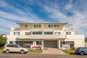 A modern two-story building with a flat roof, large windows, and a garage door. - Warners Bay Apartments (Warners Bay)
