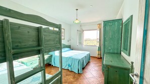 Una habitación con dos camas, una ventana y un armario verde.