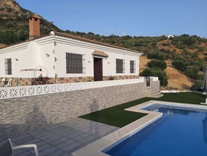 A modern house with a swimming pool, white exterior, and a stone wall. - Rural Tourist Housing Villa Madrid Alcazar (El Gastor)