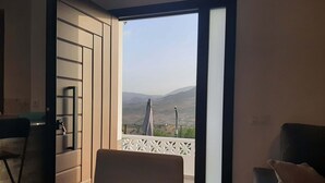 Habitación con vistas a un paisaje montañoso a través de una puerta abierta.