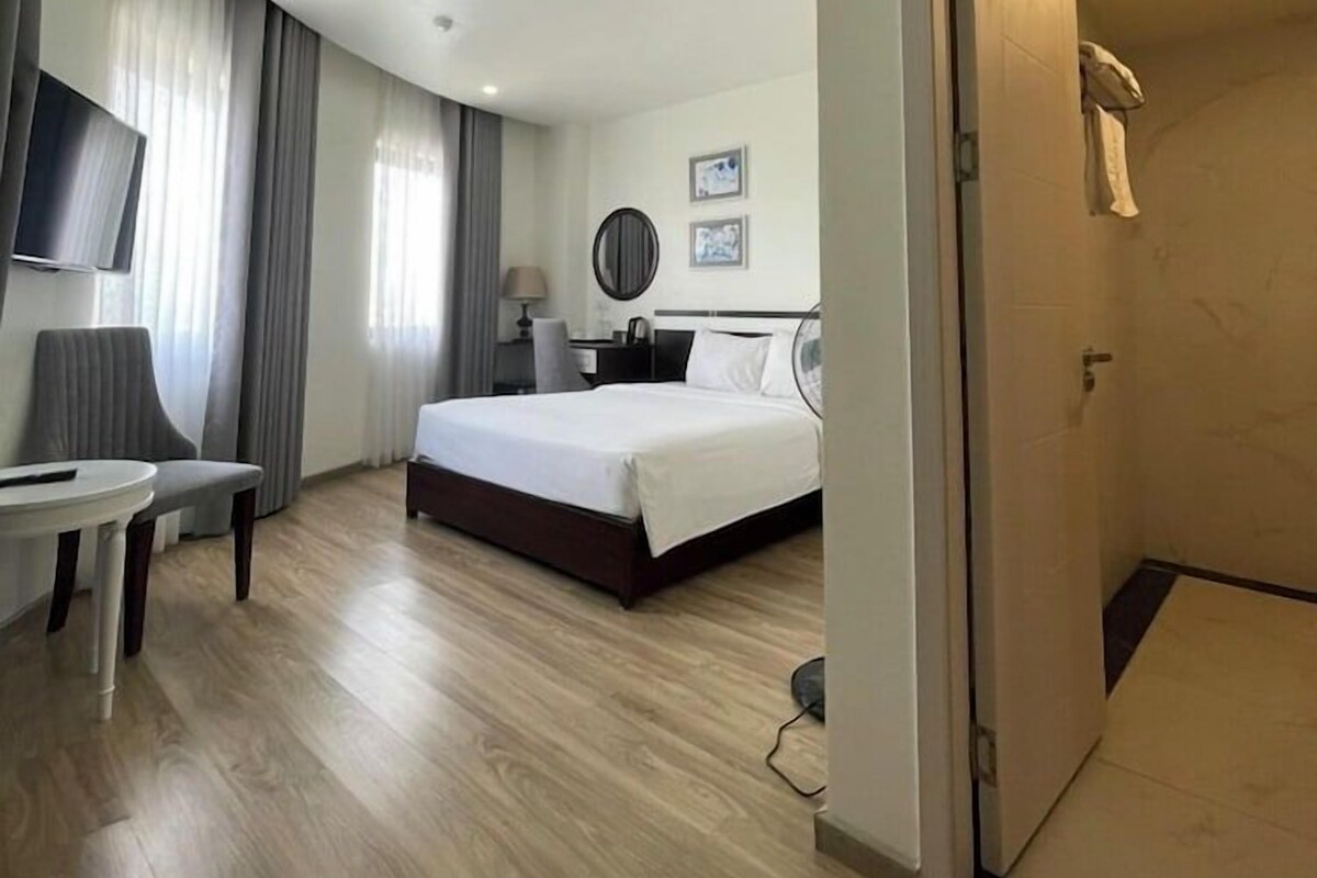Une chambre d’hôtel comprenant un lit, un bureau, une chaise, une télévision et une salle de bain.