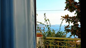 A balcony with a view of the sea and mountains, a potted plant, and a yellow railing. - Villa "Eva" - Entire Beachwalk Holiday Home - 4 Seasons & Longer Stays (Agios Dimitrios)