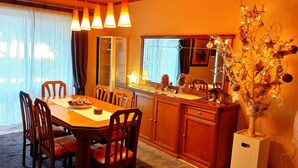 A dining area with a wooden table and chairs, a cabinet, and a decorative tree. - Villa "Eva" - Entire Beachwalk Holiday Home - 4 Seasons & Longer Stays (Agios Dimitrios)