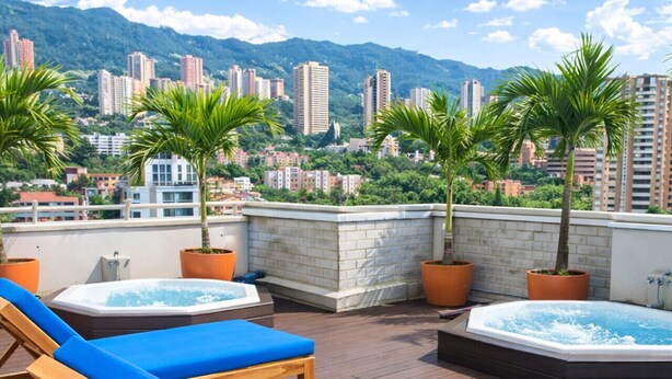 Terraza en la azotea con sillones de descanso, tinas de hidromasaje y plantas en macetas.