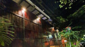 A building with a wooden exterior and a concrete pathway leading to a door. - Casa Madera · Casa Madera Parque Lleras 7BR with private Jacuzzi (Medellín)