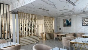 Un interior moderno con suelo de mármol, asientos lujosos y una pared decorativa con paneles verticales.