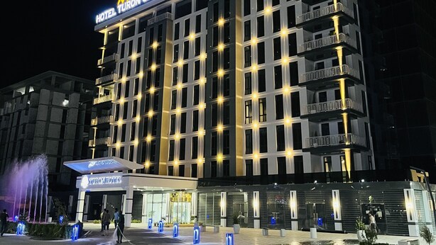 Un hotel de varios pisos con un cartel llamativo que dice "HOTEL TURON CITY PLAZA".