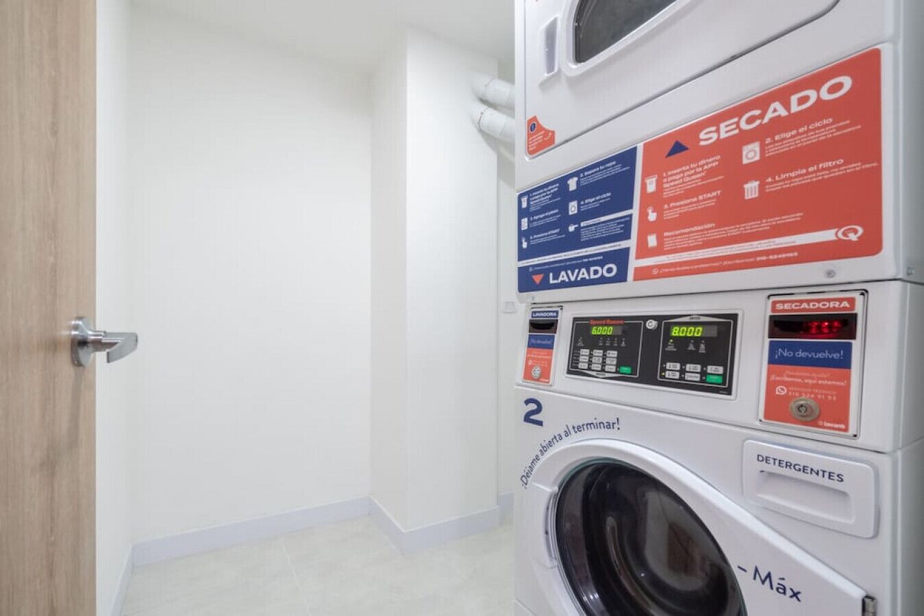 A laundry facility with a washing machine, a dryer, and a control panel with instructions.