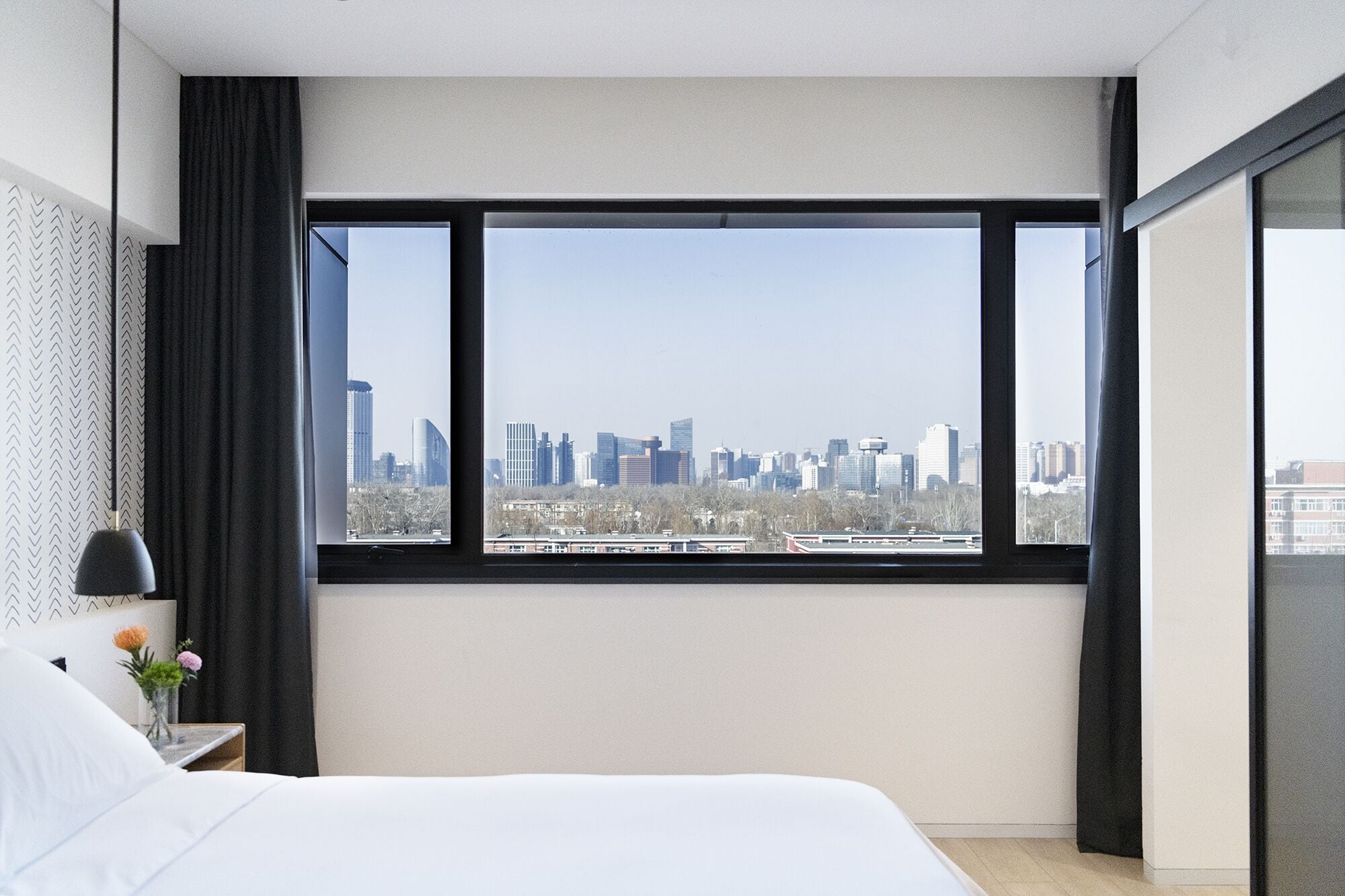 Ein Hotelzimmer mit großem Fenster und Blick auf die Stadtlandschaft.
