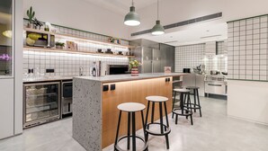 Une cuisine moderne dotée d’un îlot central, de tabourets de bar et d’un four à micro-ondes.