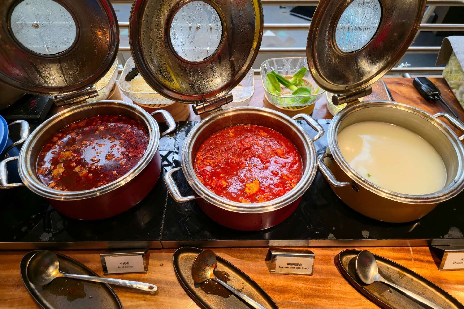 Tres recipientes de comida con etiquetas: 'Beef Gravy', 'Tomato and Egg Gravy' y 'Chicken'.