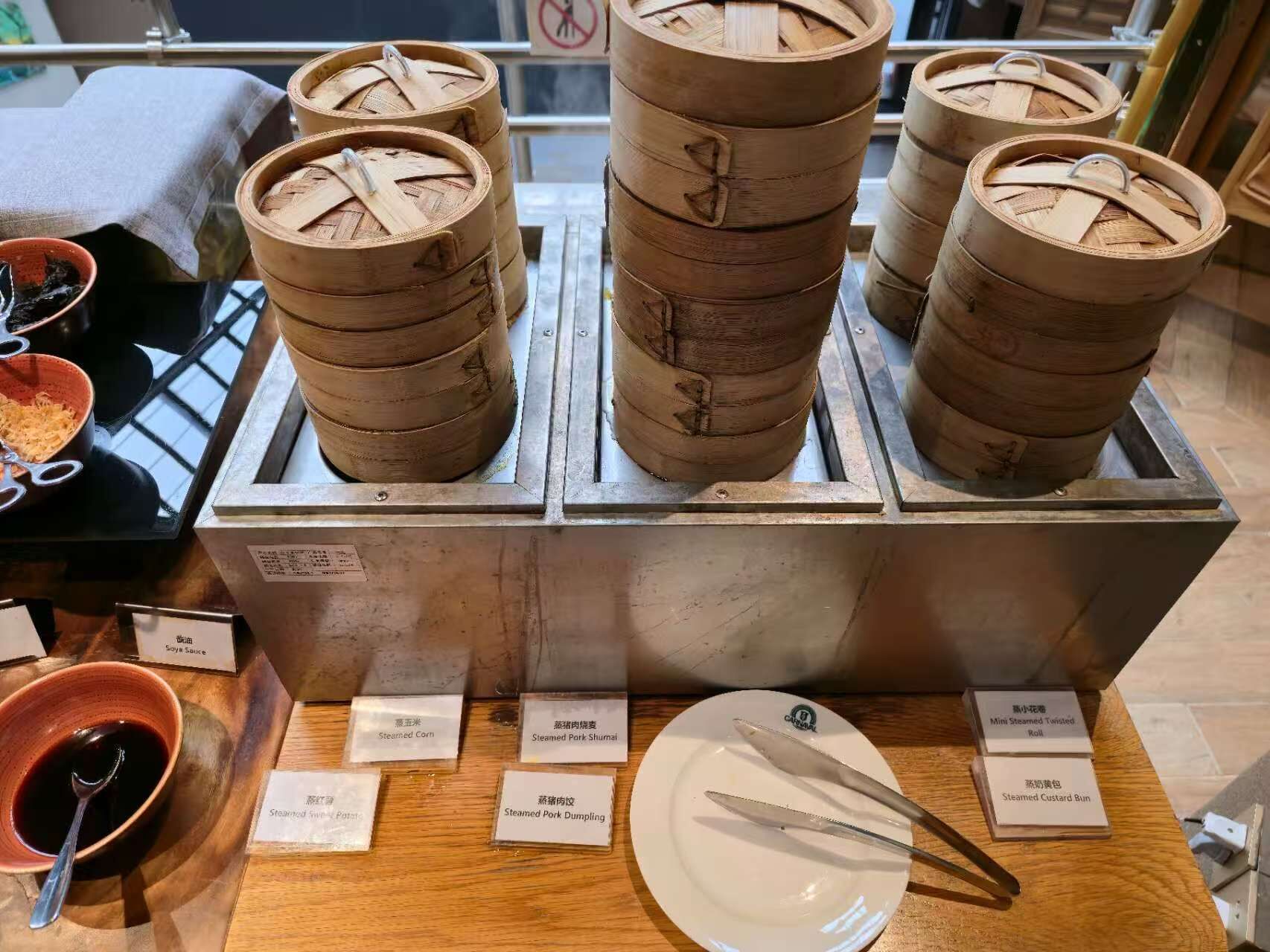 A display of traditional bamboo steamers with labels indicating various steamed dishes.