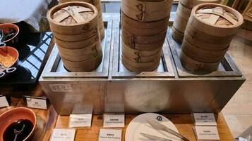 A display of traditional bamboo steamers with labels indicating various steamed dishes.