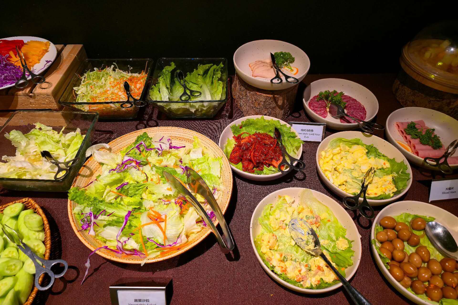 A buffet with various dishes including salads, meats, and vegetables.