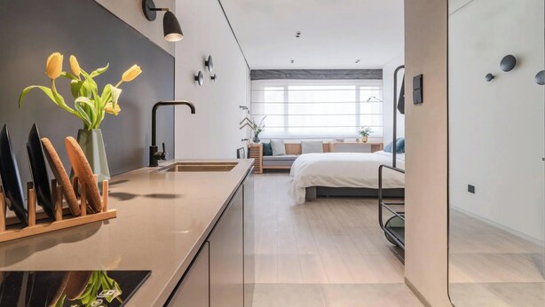 Une chambre moderne avec un lit, une table de chevet et une fenêtre donnant sur un beau paysage.
