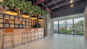 A modern bar area with wooden shelves, bar stools, and pendant lighting. - Go Living 708 · Luxury Apt-balcony and city view-AC and coworking (Medellín)