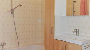 Une salle de bain avec une baignoire, un lavabo et un miroir.