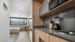 Eine moderne Küche mit Einbauherd, Kaffeemaschine und einem Messerblock.