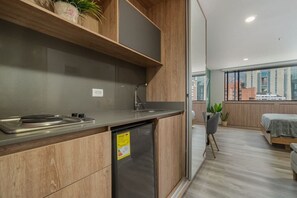 Eine moderne Küche mit Holzschnitzereien, einem integrierten Geschirrspüler und einem Fenster mit Blick auf eine Stadtlandschaft.